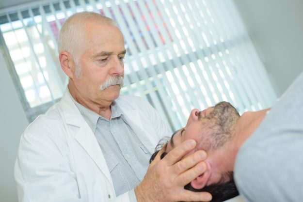 Chiropractor holding patient’s head Chiropractor holding patient's head